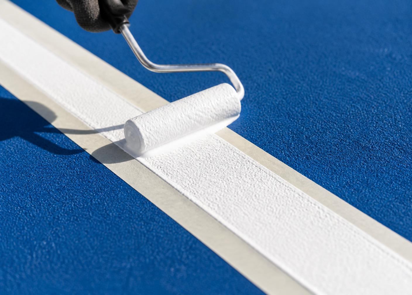 Crisp white line marking applied to a blue acrylic court surface