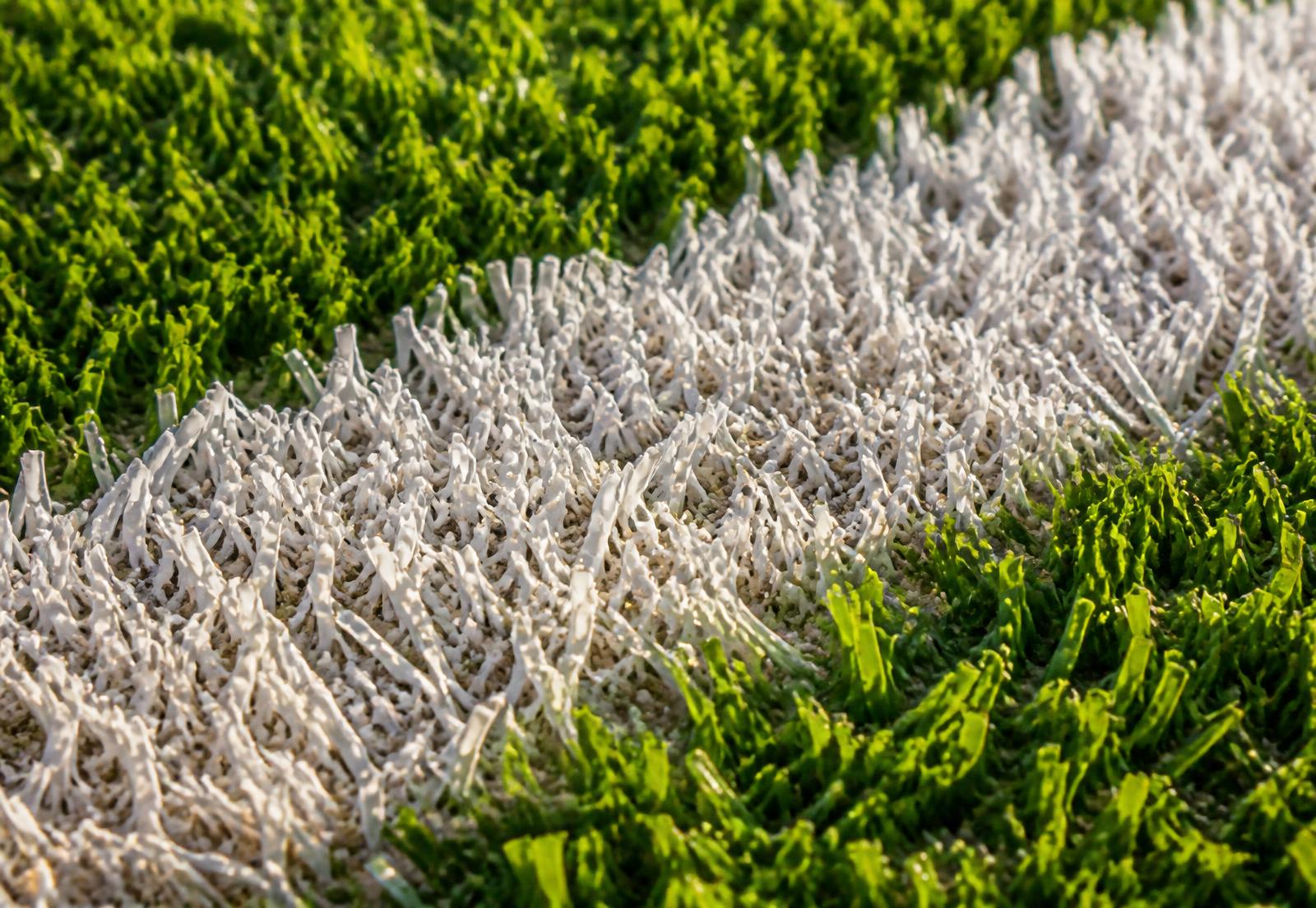 Close up of green artificial sports turf with white line marking